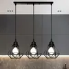 A modern kitchen counter with a three-light pendant fixture hanging above it. Produktbild-Vorschau