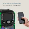 A karaoke machine is shown next to a hand holding a smartphone, illustrating Bluetooth connectivity. Produktbild-Vorschau