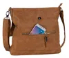 A brown leather crossbody bag with a smartphone in a front pocket. Produktbild-Vorschau
