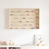 A wall-mounted display shelf filled with miniature cars. Voir les images du produit