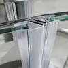 A close-up view of the corner and door mechanism of a shower enclosure. Voir les images du produit