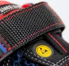 A close-up view of a safety sandal, focusing on the strap and an ESD symbol. Produktbild-Vorschau