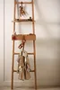 A wooden ladder shelf with decorative items and a coat hanging on it. Náhled obrázku produktu