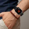 A person's arm wearing a smartwatch and a beaded bracelet. Náhled obrázku produktu