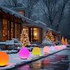 A row of colorful solar globe lights illuminate a snowy garden path in front of a modern house decorated for Christmas. Anteprima dell’immagine prodotto