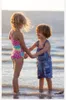 Two children holding hands in shallow water at the beach. Náhľad obrázku produktu