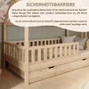 A wooden children's bed with safety rails and drawers, with text overlay describing a safety barrier. Produktbild-Vorschau