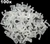 A pile of clear plastic cable clips on a black background. Produktbild-Vorschau