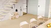 A modern interior scene featuring a wooden shelving unit with baskets, a staircase, and chairs around a table. Produktbild-Vorschau