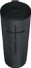A black cylindrical speaker with a textured grille and a dark top. Produktbild-Vorschau