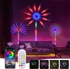 LED firework lights are displayed on a wall above a sofa in a living room, with a smartphone app and remote control shown in the foreground. Produktbild-Vorschau