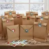 A collection of brown paper gift bags arranged on a wooden surface, with small Christmas-themed stickers attached to some of them. Produktbild-Vorschau