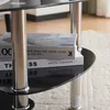 A close-up view of a glass-top coffee table with books stacked on it. Podgląd zdjęcia produktu
