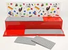 A red display case with gray Lego baseplates on the shelves and two loose gray Lego baseplates in the foreground. A printed background with Lego-themed graphics is behind the display case. Voir les images du produit