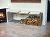 A modern living room with a fireplace and a metal firewood rack that doubles as a bench. Produktbild-Vorschau
