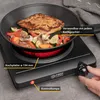 A hand is shown adjusting the knob of a black electric hot plate with a pan of food cooking on it. Produktbild-Vorschau