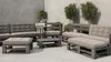 An outdoor lounge set made of wooden pallets with gray cushions, placed on a concrete patio with plants in the background. Produktbild-Vorschau