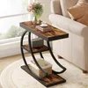 A side table with a rustic wood finish and black metal frame is placed next to a sofa in a living room setting. Produktbild-Vorschau