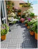 A balcony filled with potted plants and flowers, featuring a small table and chairs. Náhled obrázku produktu