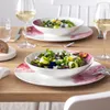 A table setting with two salads and wine glasses. Voir les images du produit