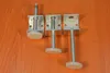 Three adjustable furniture feet are laid out on a wooden surface. Produktbild-Vorschau