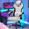 A gaming chair is shown in a room with a computer setup and neon lighting. Náhled obrázku produktu