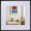 A framed picture of a red poppy on a blue background is displayed on a wall above a sofa in a living room setting. Produktbild-Vorschau