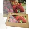 A glass cutting board with a strawberry print and a cardboard box with a window showing strawberries. Podgląd zdjęcia produktu