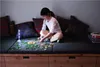 A young girl is sitting on a couch and doing a puzzle. Podgląd zdjęcia produktu