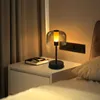 A bedside table with a lamp and a book. Anteprima dell’immagine prodotto