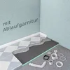 A cutaway view of a shower floor installation, showing layers of materials and plumbing components. Produktbild-Vorschau