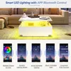 A modern living room scene featuring a white LED coffee table with yellow lighting, and below it, screenshots of a mobile app controlling the lighting. Voir les images du produit