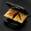A close-up view of an open sandwich toaster with two toasted sandwiches inside, set against a plain black background. Produktbild-Vorschau