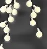 A string of white globe lights against a dark gray textured background. Náhľad obrázku produktu