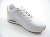 A white Skechers sneaker with pink accents and a brown sole is shown against a white background. Voir les images du produit