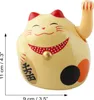 A yellow Maneki-neko (lucky cat) figurine with red ears and a red polka dot collar. Produktbild-Vorschau