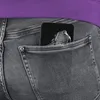 A close-up view of a smartphone and keys in a back pocket of gray jeans. Anteprima dell’immagine prodotto