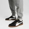 A person wearing Puma Club II Era Uni sneakers and grey sweatpants. Voir les images du produit