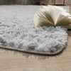 A close-up shot of a fluffy, light gray rug with an open book resting on it. Produktbild-Vorschau