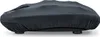 A black fabric cover is draped over a massage device, obscuring most of its details. The device rests on small black feet. Produktbild-Vorschau