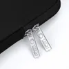 A close-up shot of two silver zipper pulls on a black laptop sleeve. Náhľad obrázku produktu