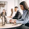 People in an office setting, with a water bottle in the foreground. Produktbild-Vorschau