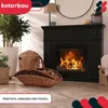 A fireplace with a fire burning, surrounded by decorative elements like plants and baskets filled with firewood. Náhľad obrázku produktu