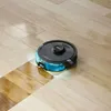 A robot vacuum cleaner is cleaning a wooden floor. Produktbild-Vorschau