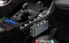 A car's center console with various electronic devices charging. Podgląd zdjęcia produktu