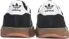 The back view of two black Adidas sneakers with white logos and brown soles. Produktbild-Vorschau