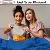 Two young women are sitting on a couch, watching TV and eating chips. Produktbild-Vorschau