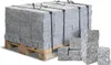 A pallet of granite paving stones is shown, with a few individual stones in the foreground. Produktbild-Vorschau