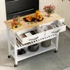 A kitchen cart with a wooden top, white frame, and drawers, filled with kitchen items and fruit. Podgląd zdjęcia produktu