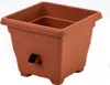 A brown square planter pot with a lip and four small feet. It has a rectangular cutout on one side. Produktbild-Vorschau
